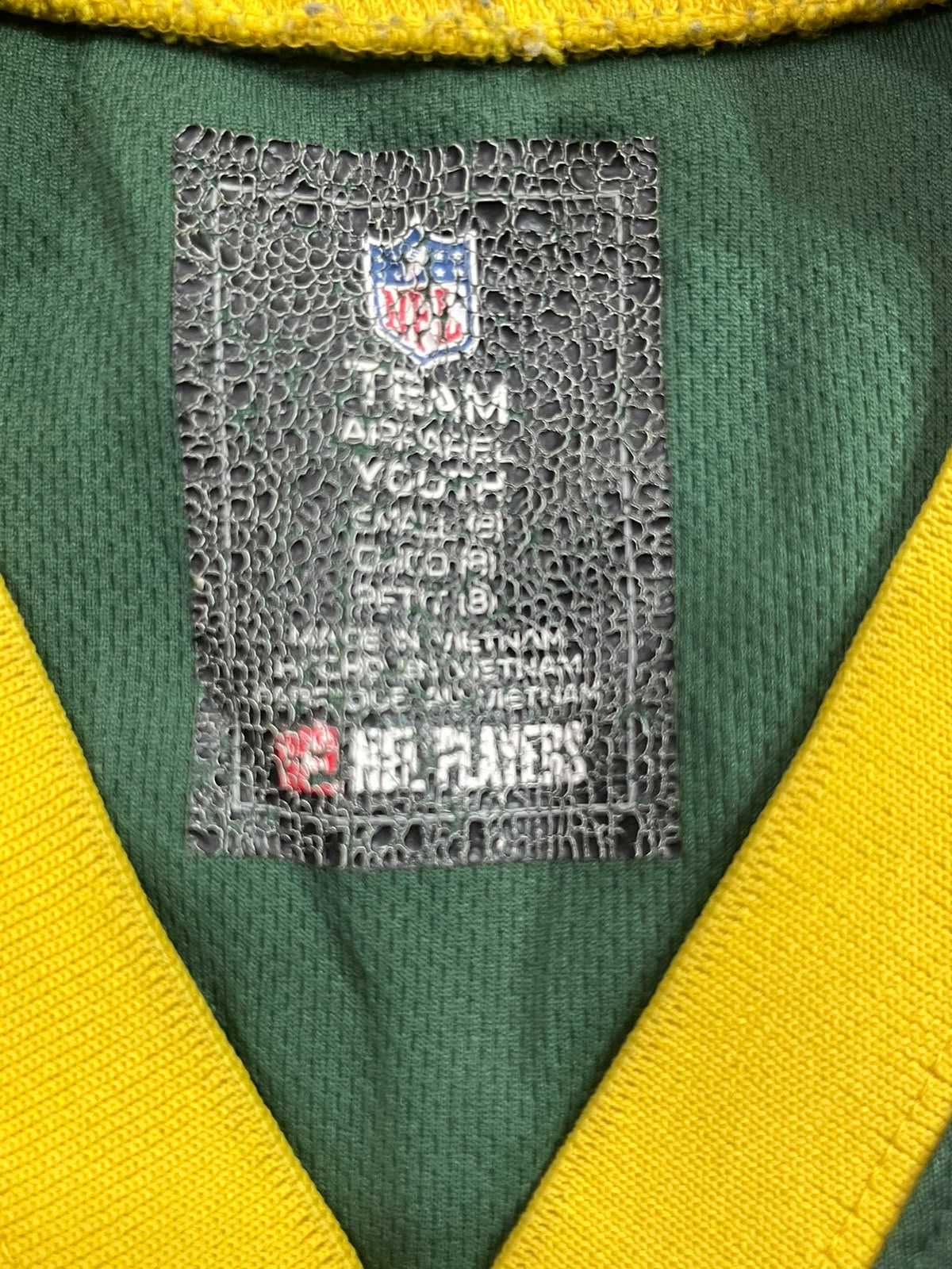 Close-up of a green and yellow NFL jersey interior showing the NFL Team Authentic Youth label.