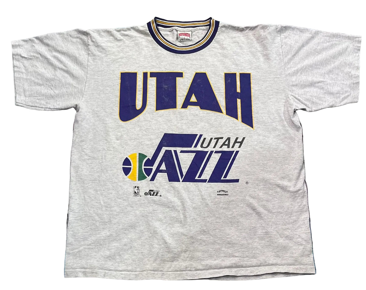 A light heather gray short-sleeve Utah Jazz t-shirt l The shirt features a large navy blue and gold 'UTAH' logo above the Utah Jazz team logo.