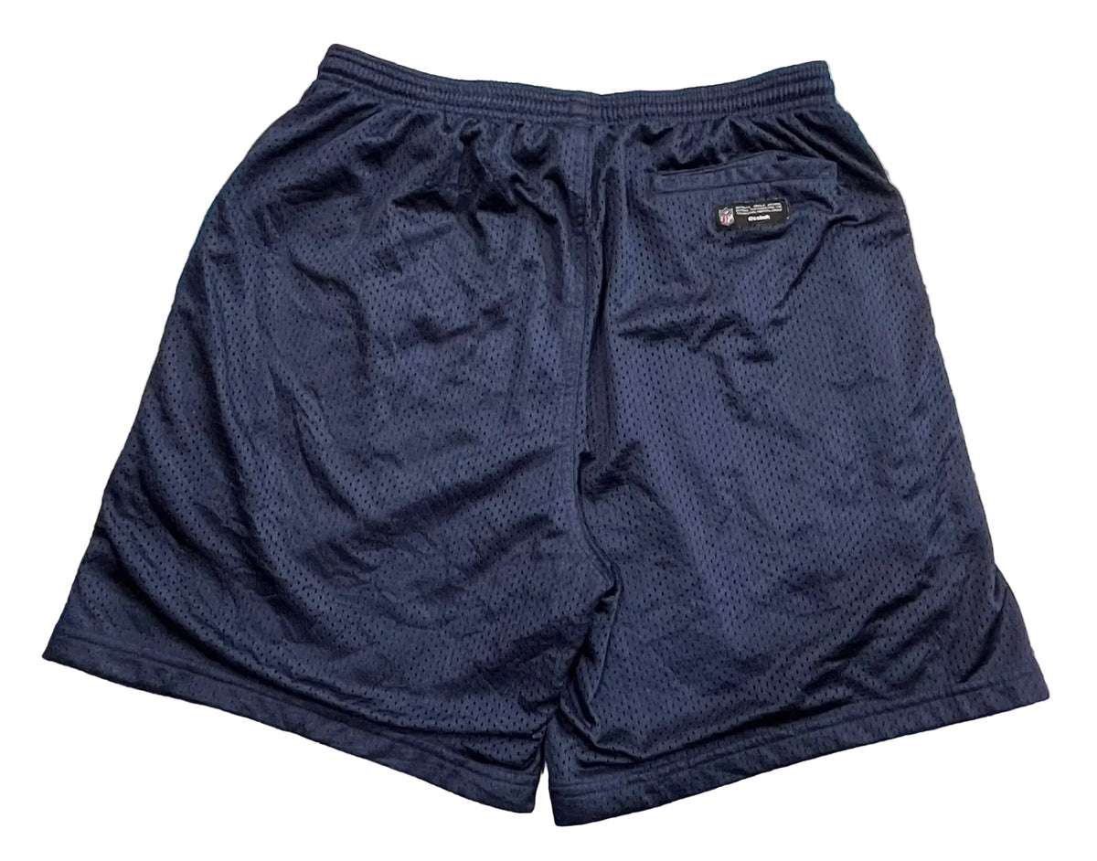 A pair of navy blue athletic shorts with a textured mesh fabric, A small black and white 'PUMA' brand tag is visible on the upper right side.