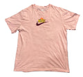 A light pink short-sleeve Nike t-shirt . The shirt features a small graphic on the left chest with a yellow and orange Nike logo and a dark purple swoosh.