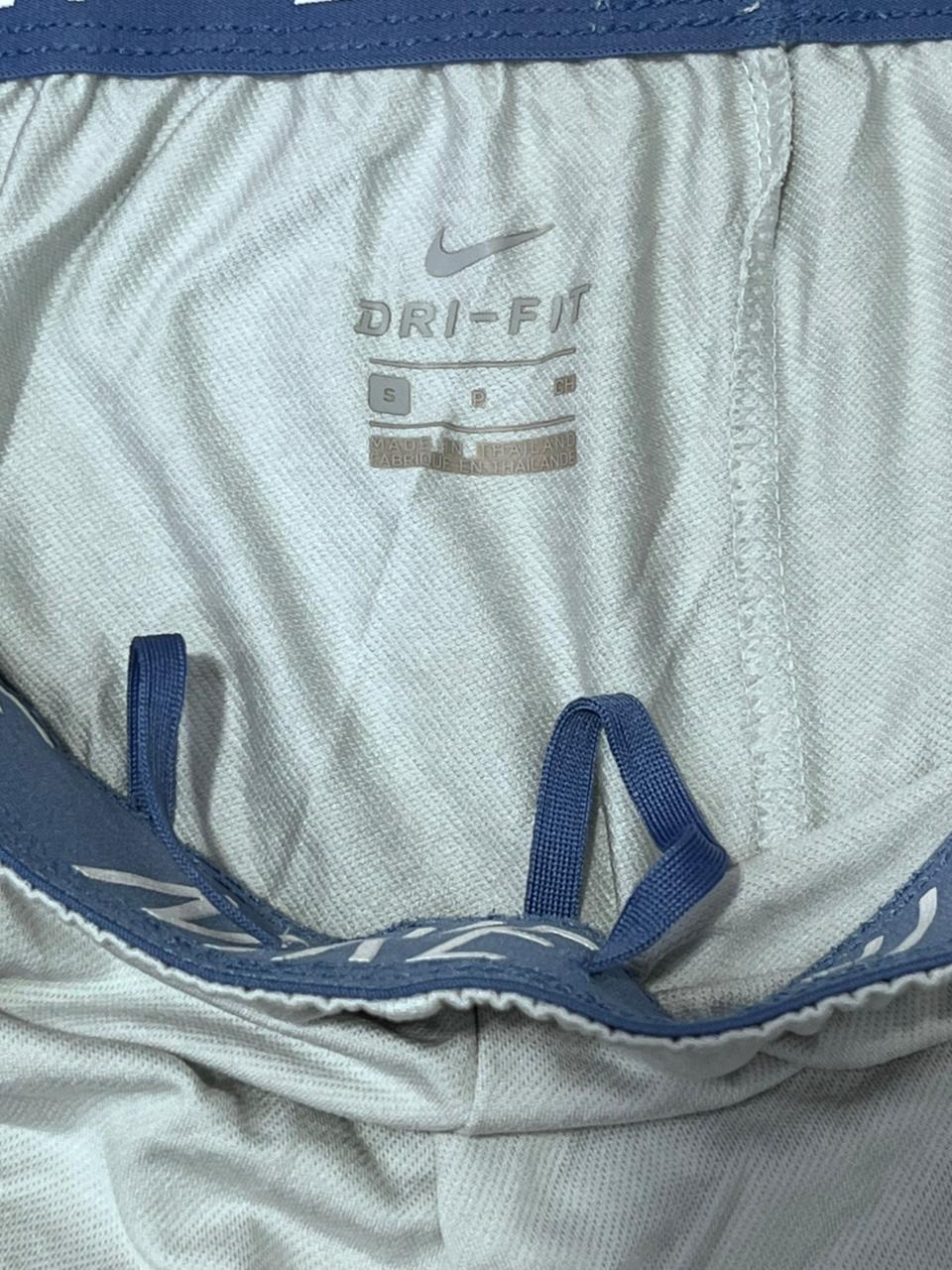 White athletic shorts with blue waistband and Nike Dri-FIT logo