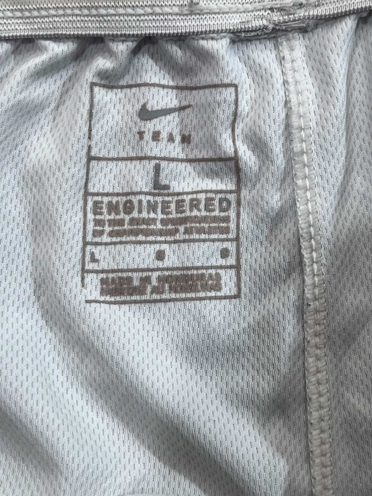 Close-up of the inside waistband of a Nike athletic garment, showing a size label marked L and the Nike swoosh.