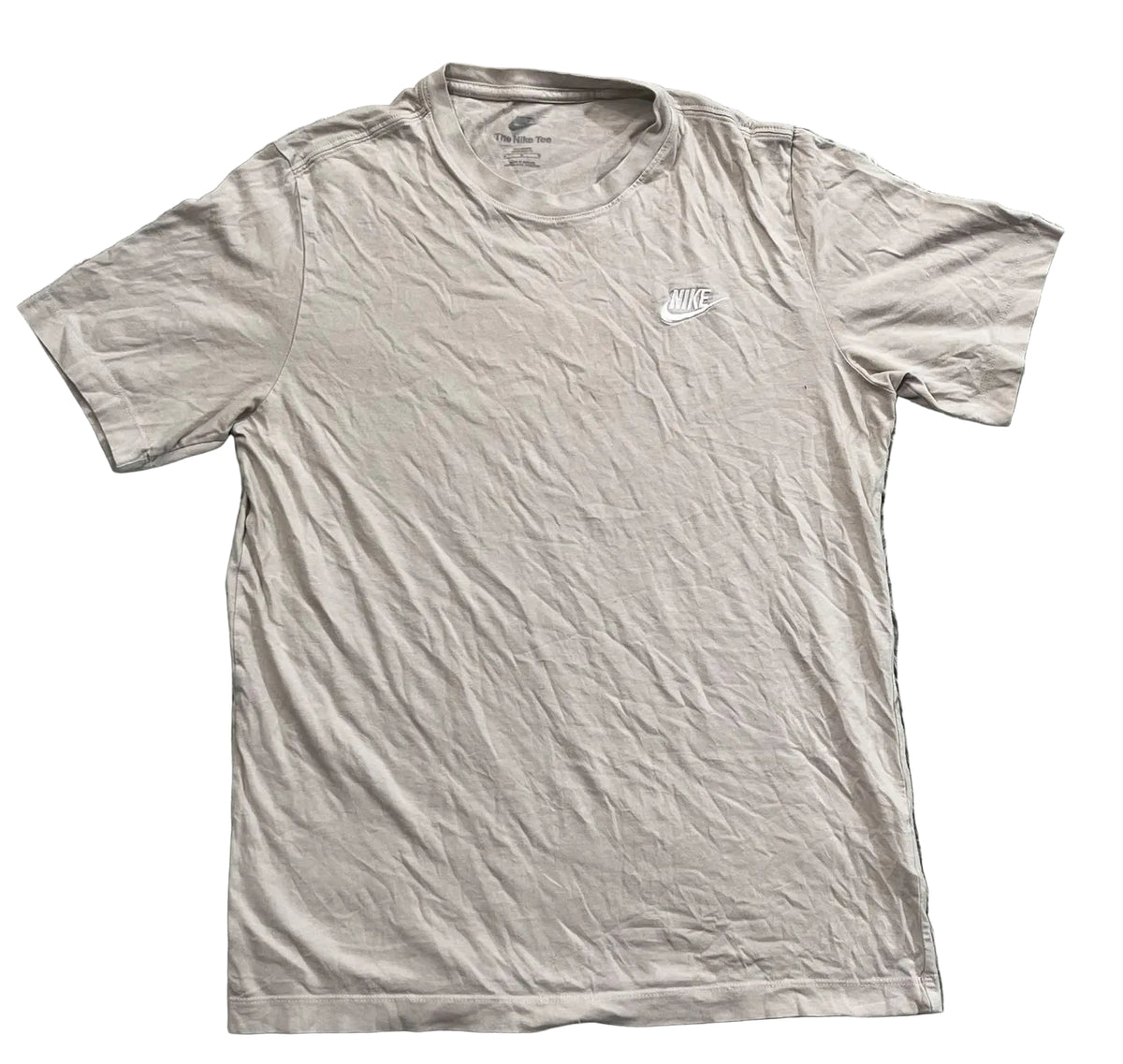 A light beige Nike short-sleeve t-shirt with a small white logo on the left chest, 