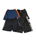 Four pairs of athletic shorts The shorts include navy blue with orange side panels, black with white side stripes, black with gray mesh panels, and black with a small white logo.