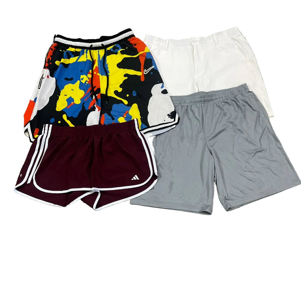 Four pairs of athletic shorts a multicolor abstract-print pair, a white pair, a maroon pair with white side stripes, and a light gray pair.