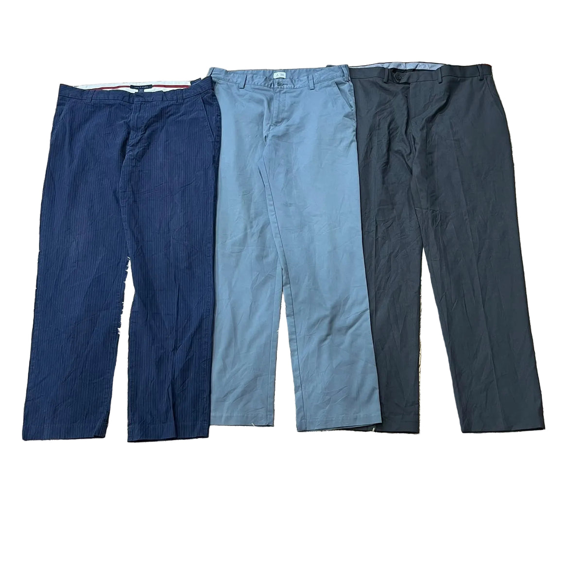Three pairs of casual trousers: one dark navy blue, one muted light blue, and one charcoal gray.