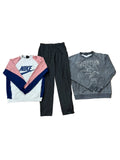 Three clothing items: a Nike colorblock sweatshirt in white, pink, and navy; a pair of black jogger pants; and a gray Led Zeppelin graphic sweatshirt. Bare feet are visible at the bottom edge.