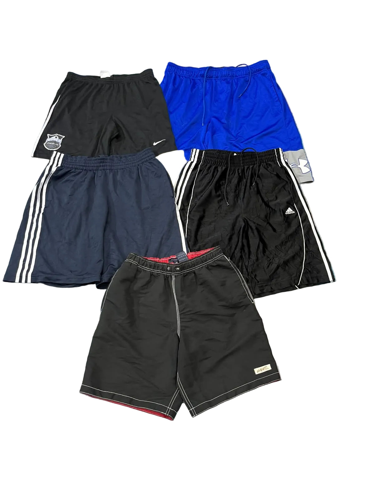 Five pairs of athletic shorts in various colors (black, blue, navy, and dark gray) are . The shorts include different styles and logos, such as Nike, Adidas, and a shield emblem.