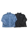 Two lightweight zip-up jackets one light blue Patagonia jacket on the left and one black Columbia jacket on the right.