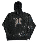 A black pullover hoodie with a white and blue paint splatter pattern and a large gray stylized 'H' logo on the chest,