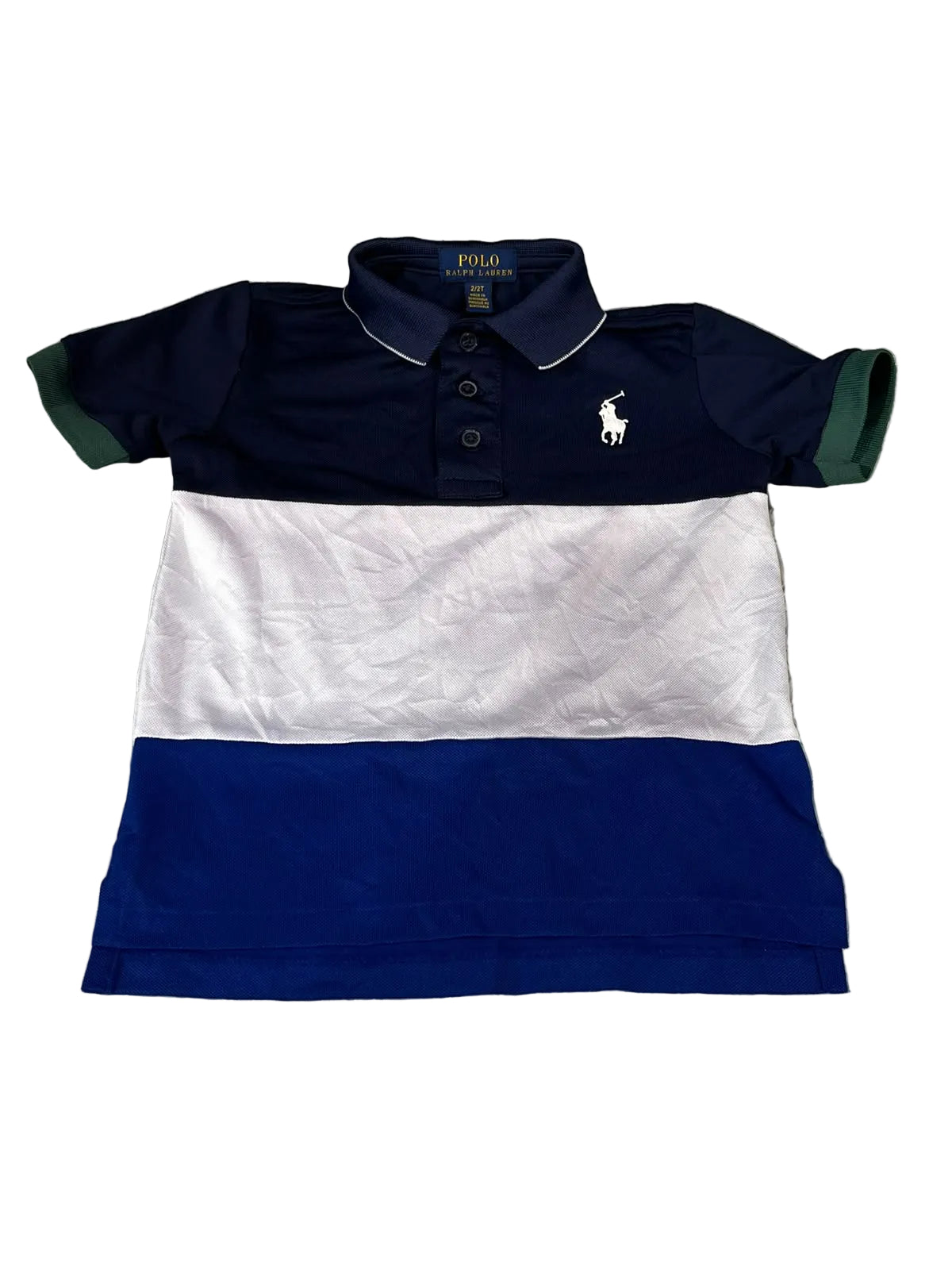 A Polo Ralph Lauren colorblock short-sleeve polo shirt for kids, featuring navy blue, white, and royal blue horizontal stripes with green sleeve cuffs, laid flat on a gray shag rug.