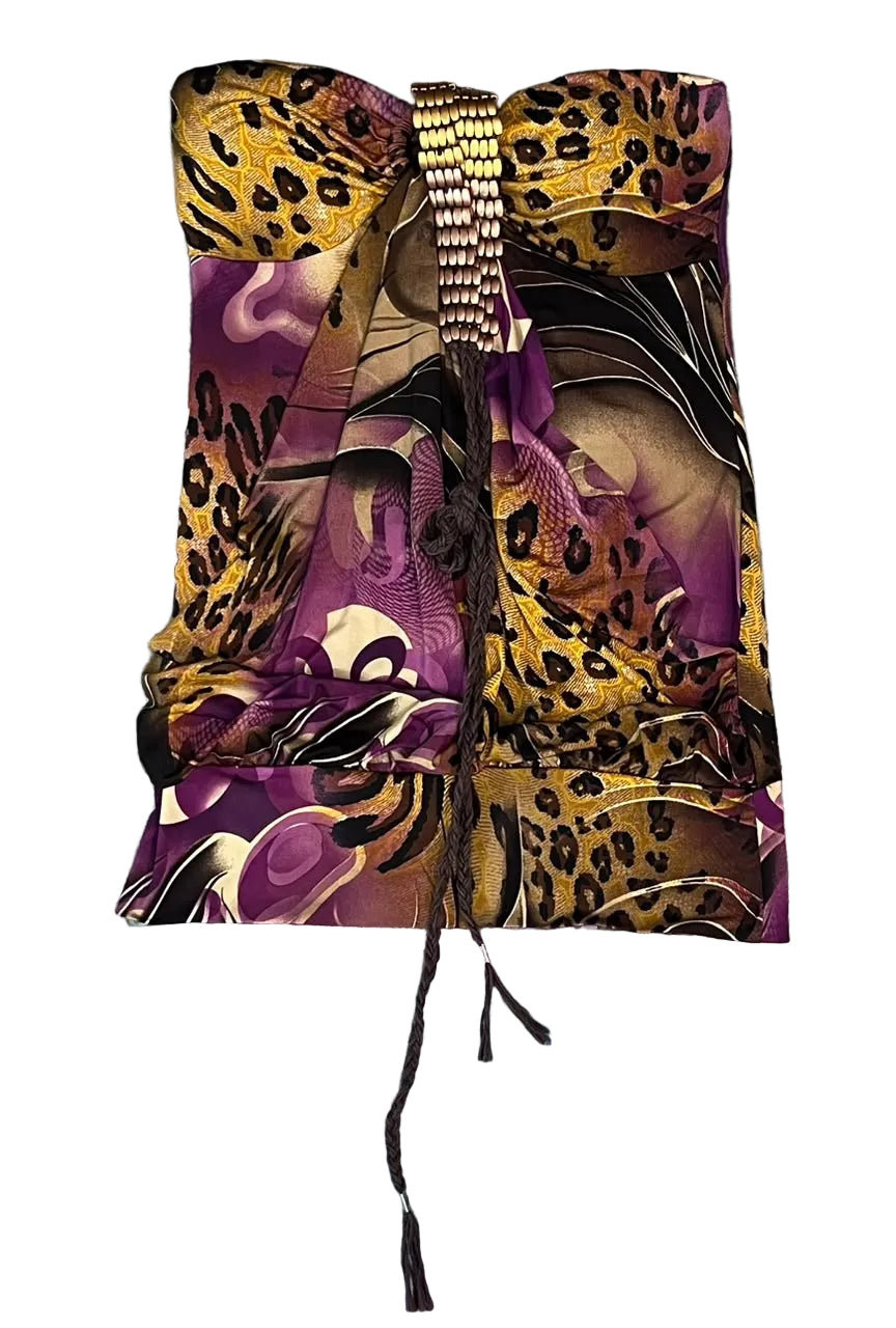 A folded fashion scarf with a mixed print of leopard print, purple abstract waves, and black/white details, featuring a silver beaded top band and a long black tassel,