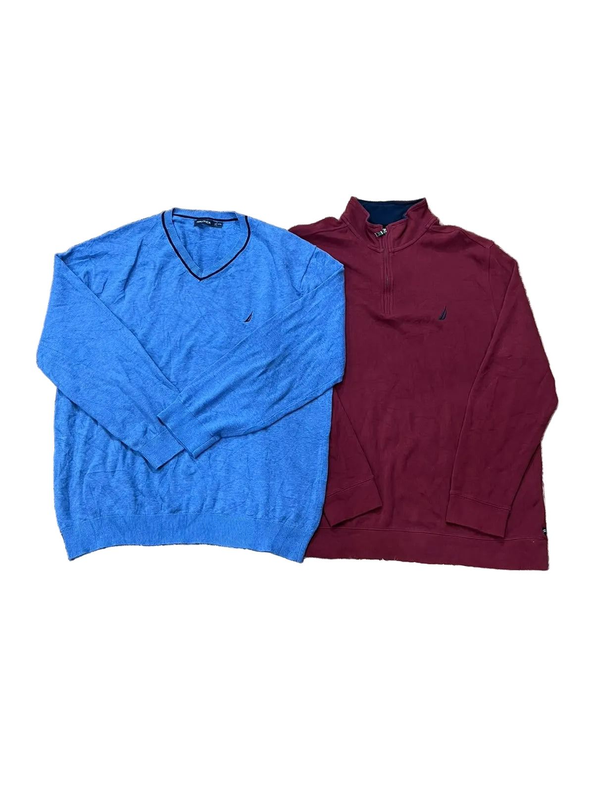 Two men's quarter-zip long-sleeve sweaters laid flat on a beige shag rug. The sweater on the left is a heathered medium blue with a dark V-neck trim and a small navy embroidered logo.