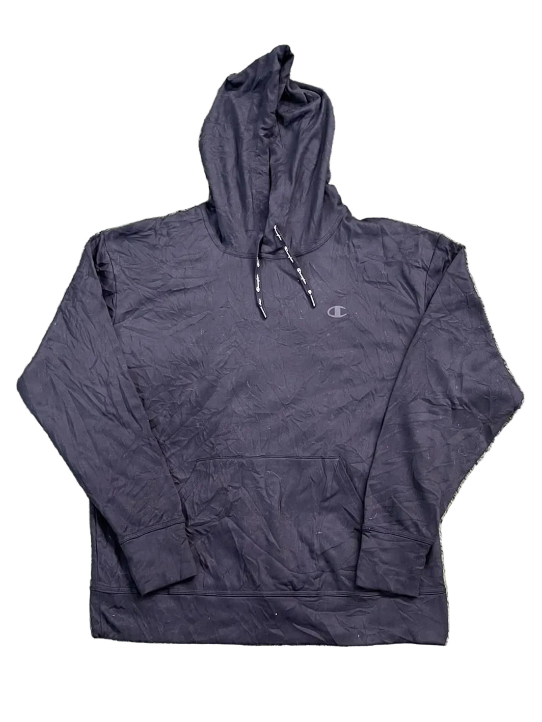 A black Champion pullover hoodie is with bare feet visible at the bottom edge of the frame.