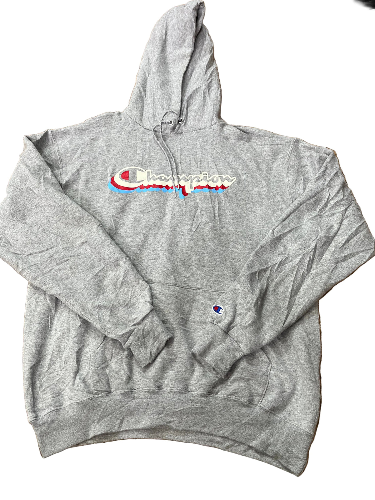 A heather gray Champion hoodie with a red, white, and blue embroidered logo on the chest, with other clothes visible in the background.