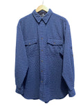 The north face blue plaid shirt on a hanger against a white wall