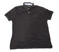 A black short-sleeve polo shirt by Tommy Hilfiger,. The shirt features a three-button placket and the signature embroidered Tommy Hilfiger flag logo on the left chest.
