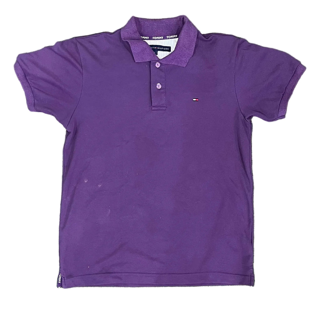 A purple short-sleeve polo shirt with a three-button placket and a small embroidered Tommy Hilfiger flag logo on the left chest, on a white plain background 