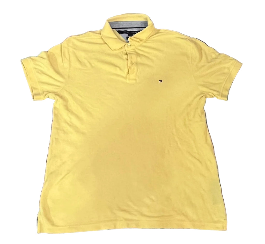 A yellow short-sleeve polo shirt t. A small embroidered Tommy Hilfiger flag logo is visible on the left chest.