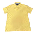 A yellow short-sleeve polo shirt t. A small embroidered Tommy Hilfiger flag logo is visible on the left chest.