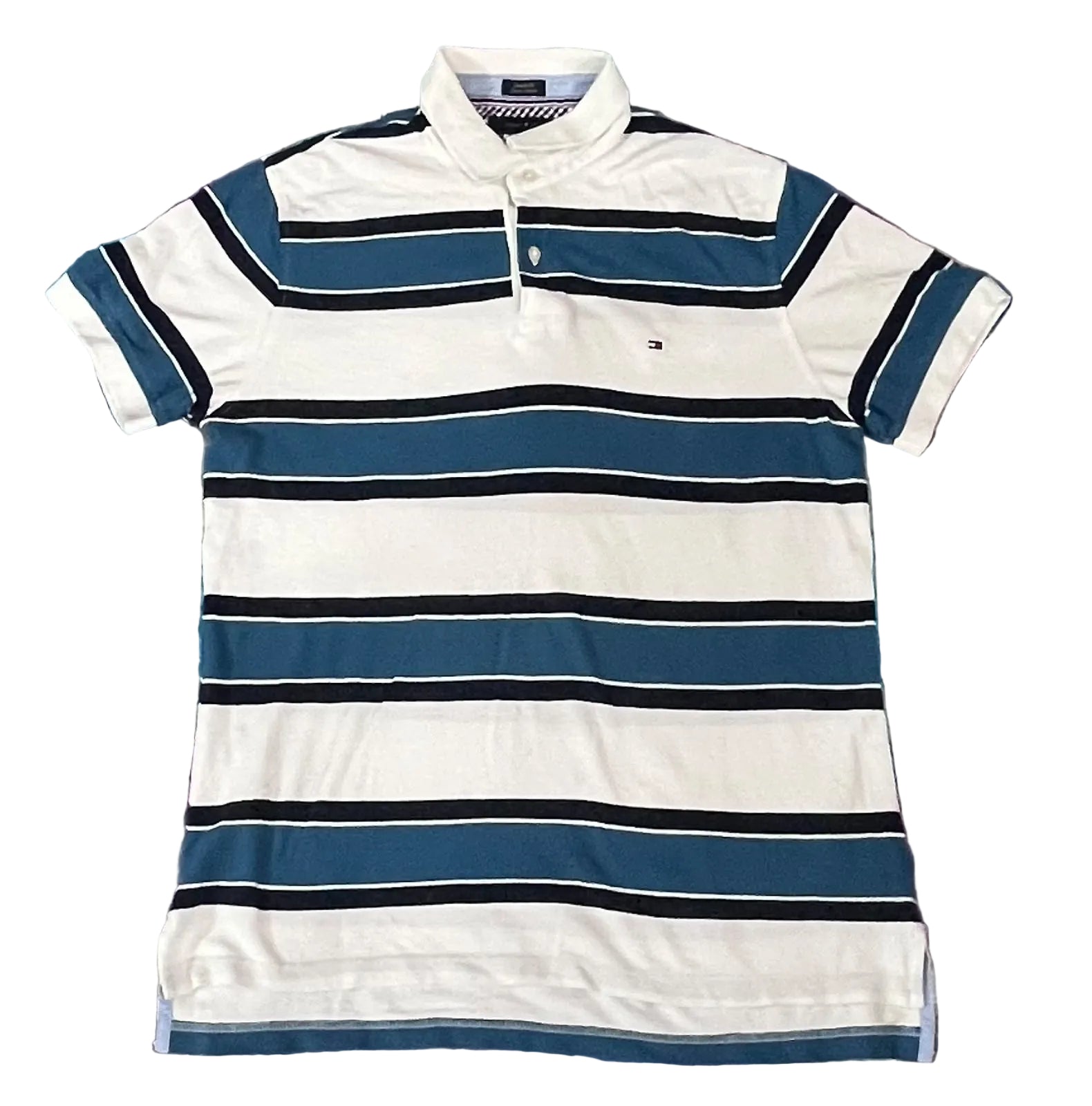 A short-sleeve striped polo shirt with horizontal bands of white, dark blue, and black, featuring a small embroidered Tommy Hilfiger flag logo on the left chest,