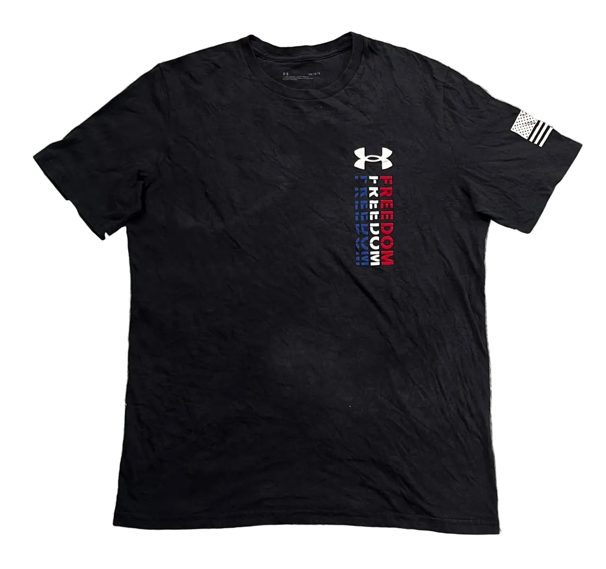A black Under Armour short-sleeve t-shirt . The shirt features a white Under Armour logo above a vertical graphic reading 'FREEDOM' in white, blue, and red stripes.