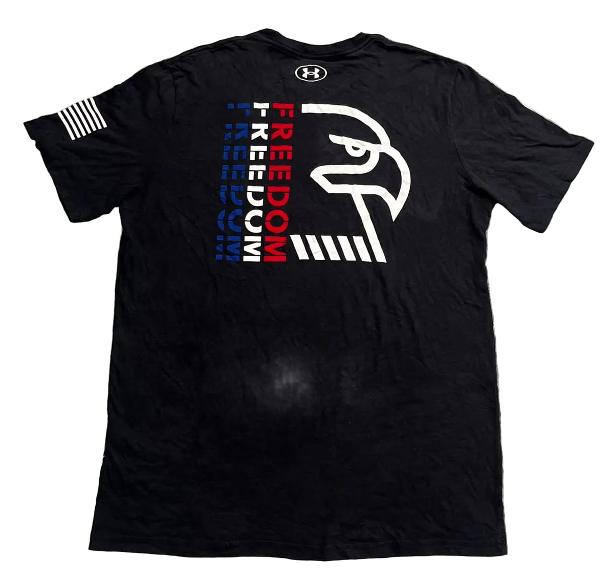 A black Under Armour t-shirt , featuring a large graphic on the back with a white eagle head, vertical text in blue and red, and a small white flag print on the sleeve.