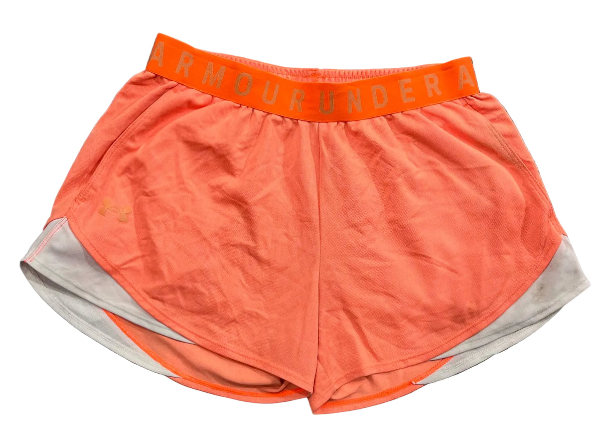 A pair of bright orange athletic shorts with a matching orange waistband featuring the Under Armour logo,