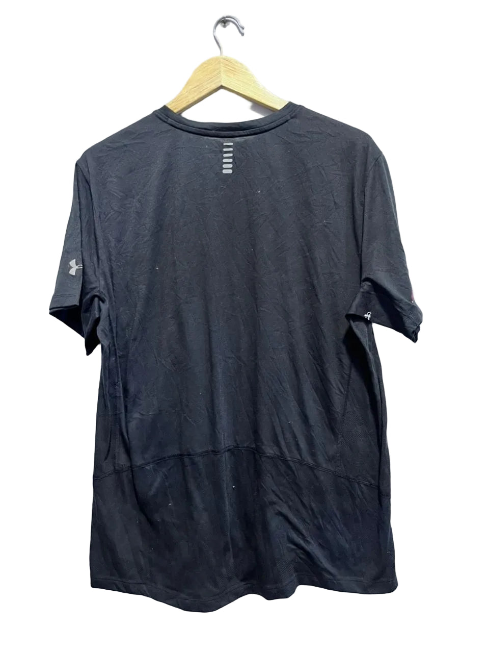 Black t-shirt on a hanger against a white wall