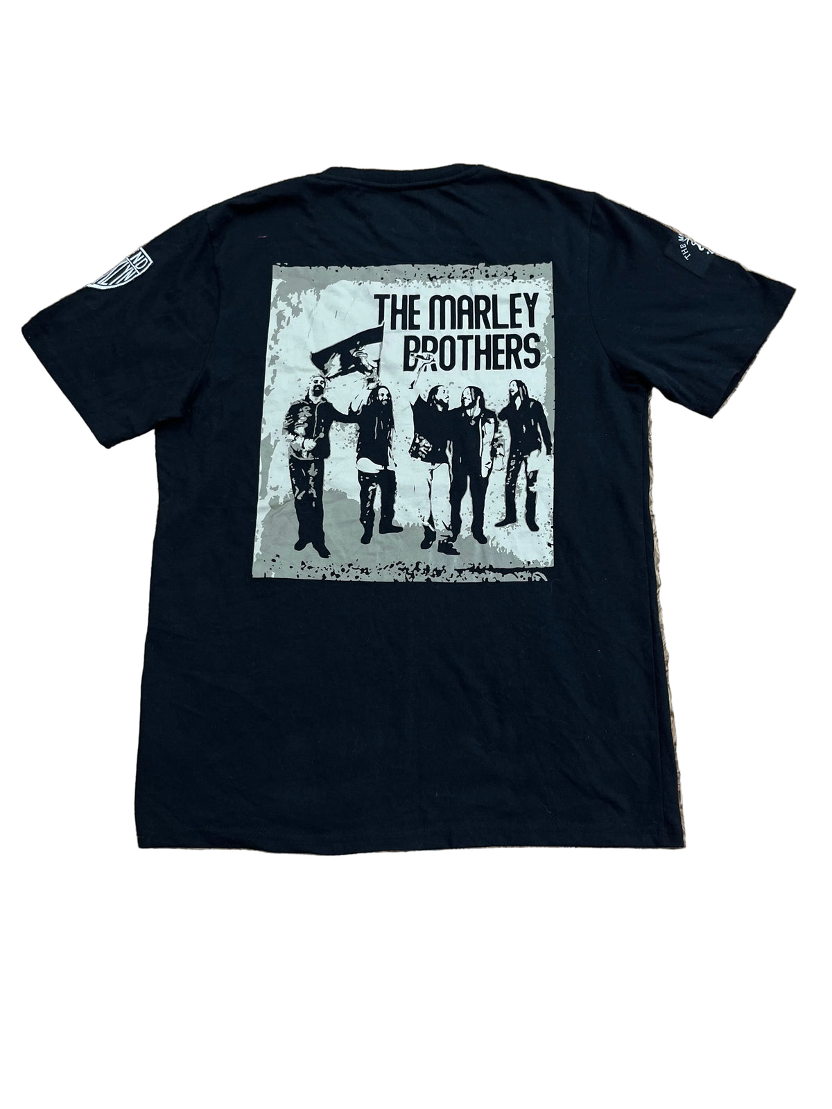 A black short-sleeve t-shirt, featuring a large front graphic print of The Marley Brothers band members in black and white.