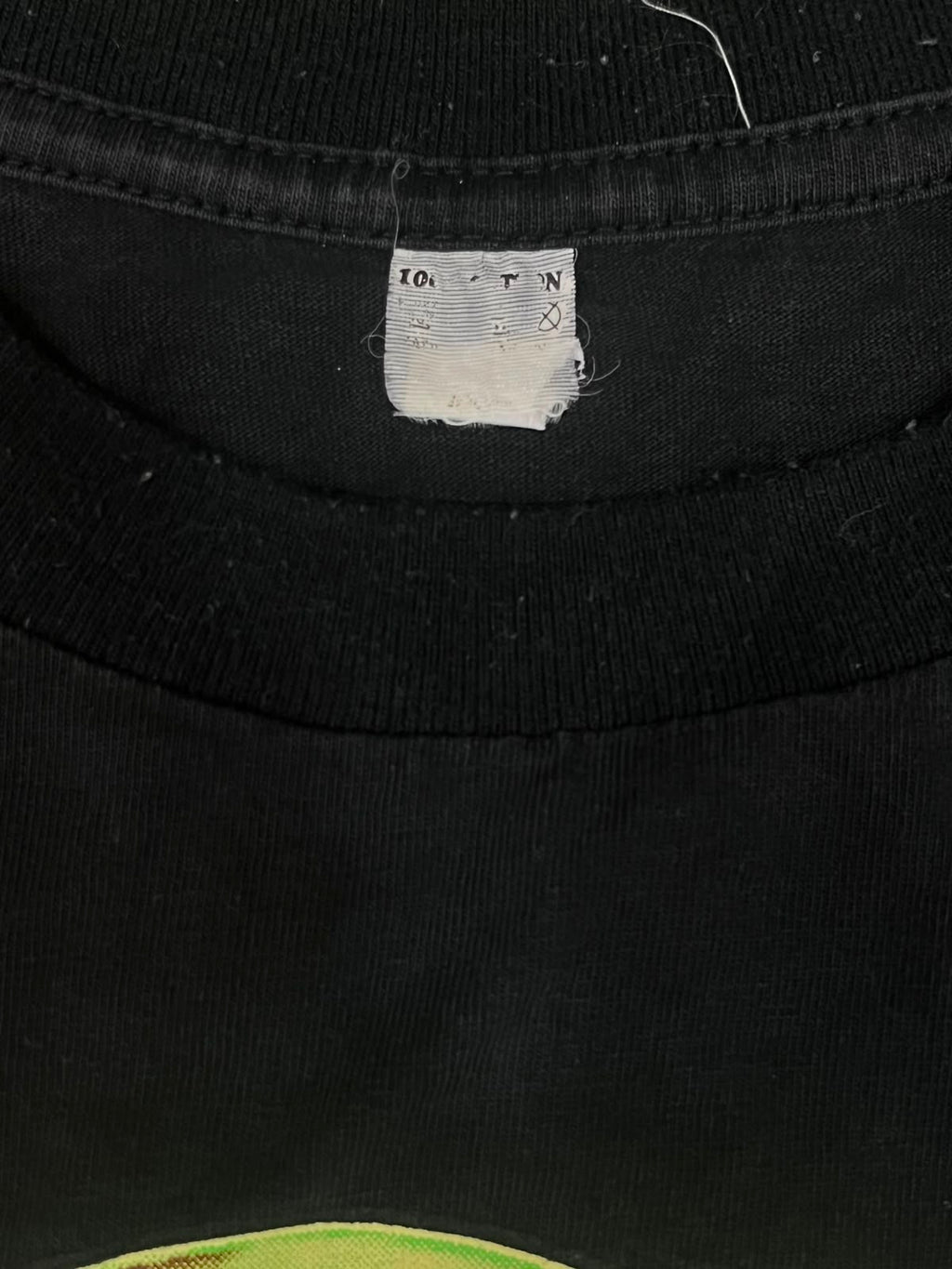Close-up of a black cotton t-shirt neck label showing the brand '10 for 1' and size information.