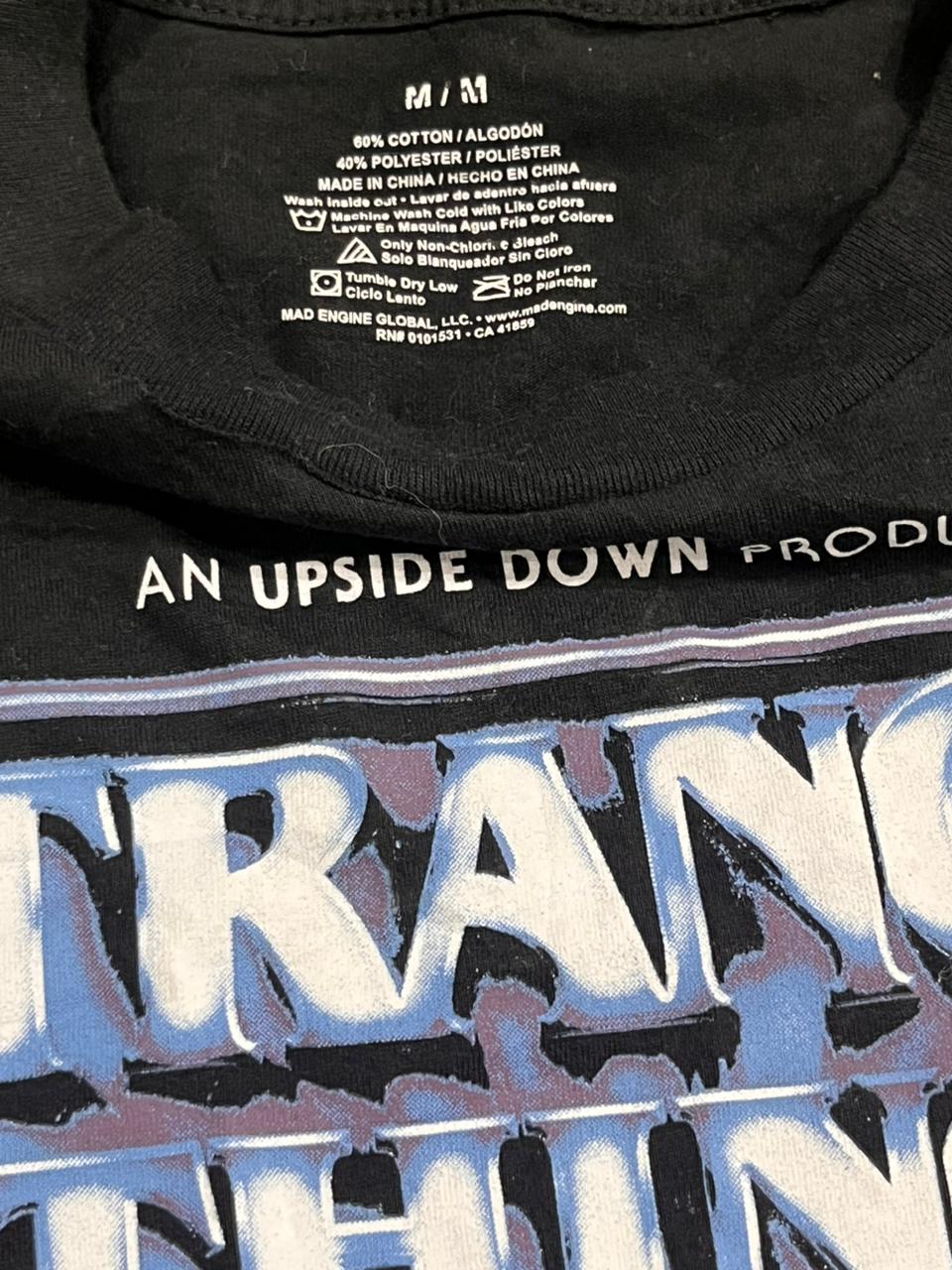 Black t-shirt with text and branding details, including a visible brand logo.