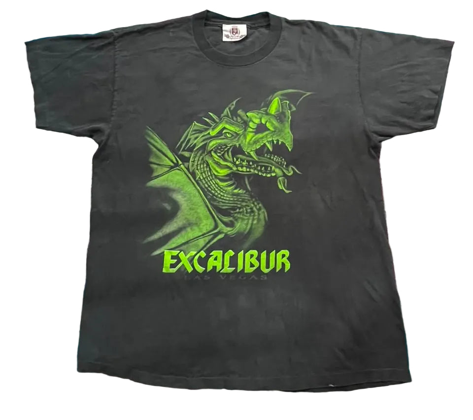 A black short-sleeve graphic t-shirt featuring a green dragon illustration and the text 'EXCALIBUR' in neon green,