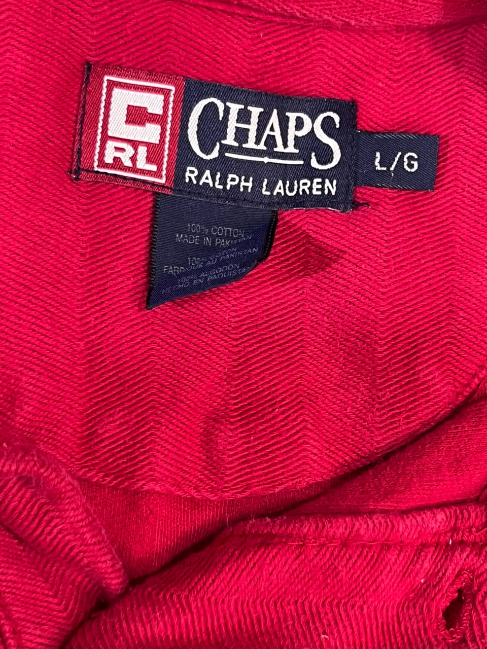 Close-up of a red textured garment label reading CHAPS RALPH LAUREN with a CRL logo and size L/G.