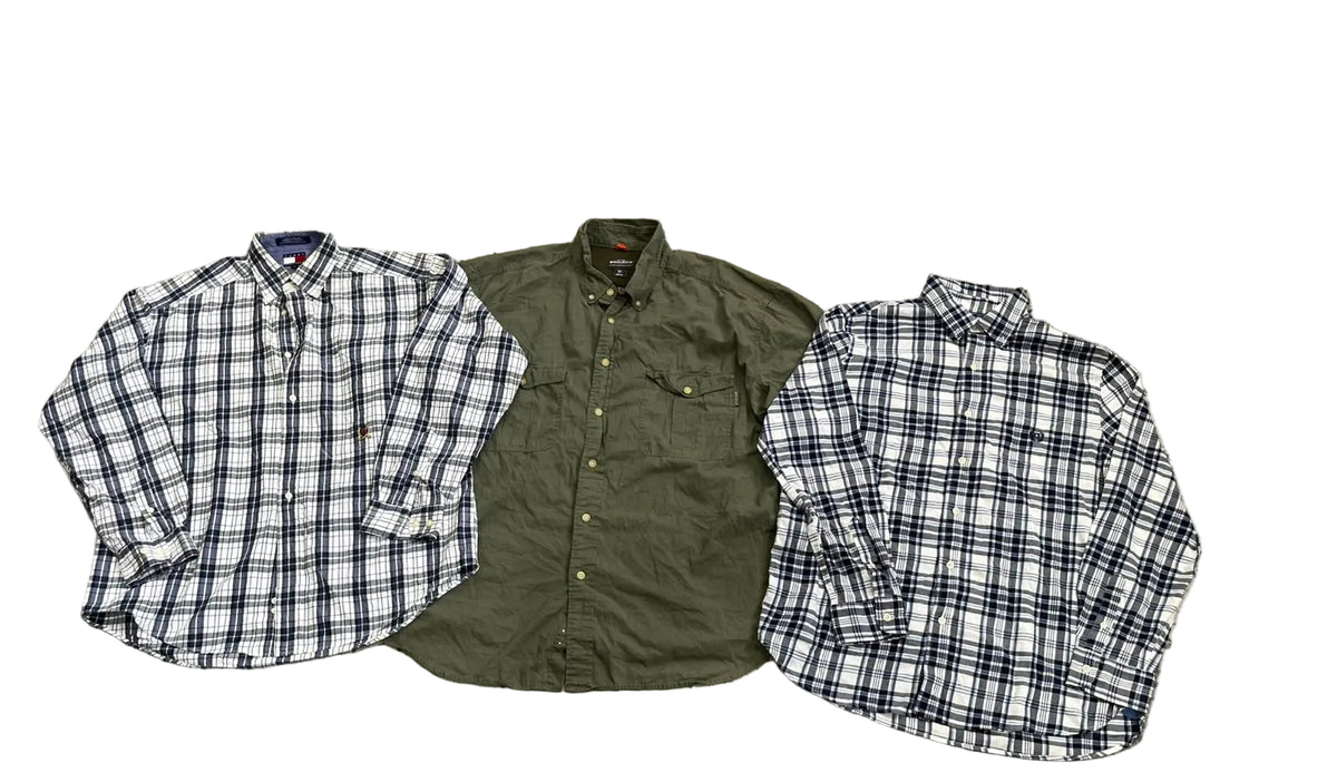 Three folded long-sleeve button-up shirts a white shirt with blue and black plaid on the left, an olive green shirt in the center, and a white shirt with blue and black plaid on the right.