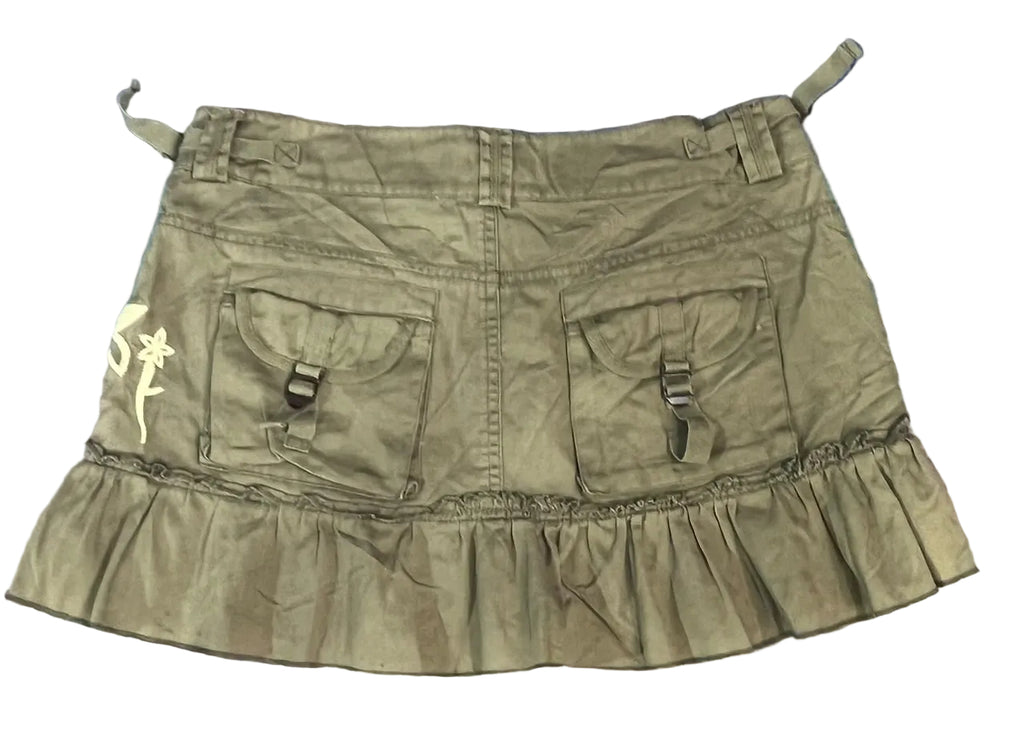An olive green ruffled mini skirt with two front utility pockets and buckle details