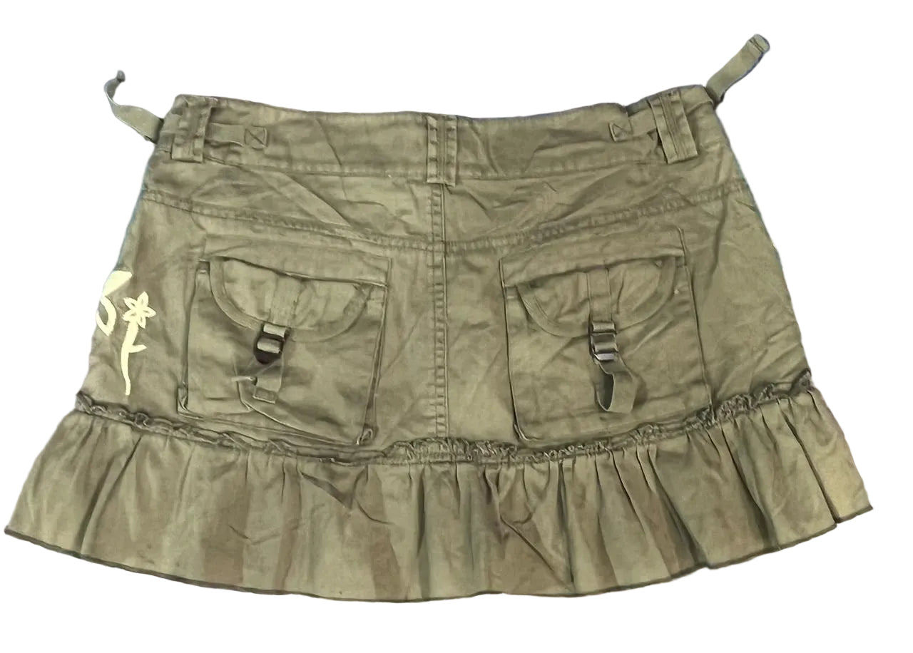 An olive green ruffled mini skirt with two front utility pockets and buckle details